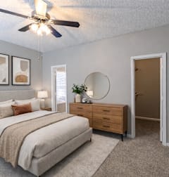A bedroom with a bed, dresser, and mirror at Austin Chase Apartments, Georgia 31210