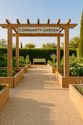 A community garden with a wooden sign that reads "Community Garden" in front of a row of plants.