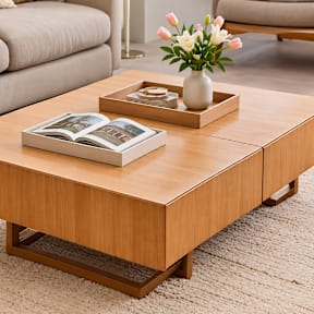 A coffee table with a book and a vase of flowers on it.
