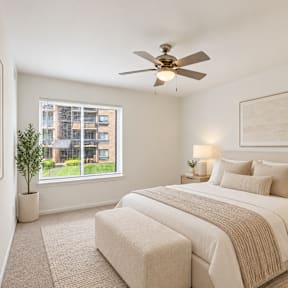 A bedroom with a bed, desk, and chair.