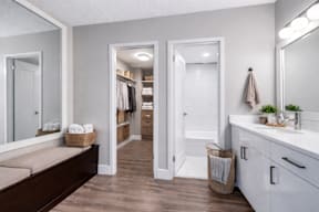 A bathroom with a white vanity and a large mirror.