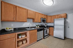 A kitchen with wooden cabinets and a black countertop.