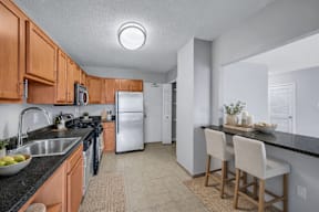 A kitchen with wooden cabinets and a black countertop.