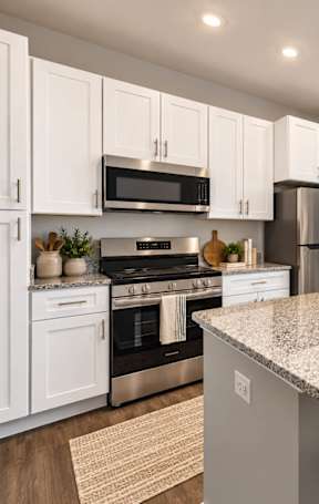 an open kitchen with a granite counter top and stools