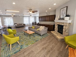 A living room with a fireplace and a yellow chair.