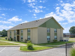 A large building with a green roof and beige walls.