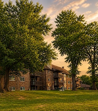 A large brick building with a green lawn in front.