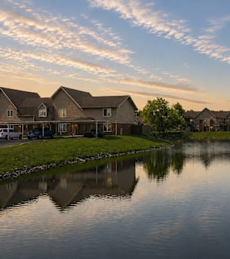 A serene lake in a residential area with houses on the side.