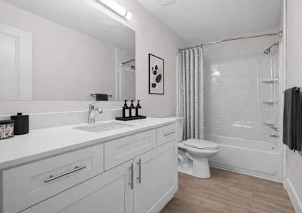 A white bathroom with a toilet, sink, and bathtub.