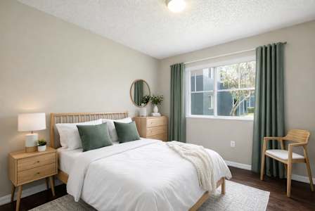 A bedroom with a bed, nightstand, and chair.