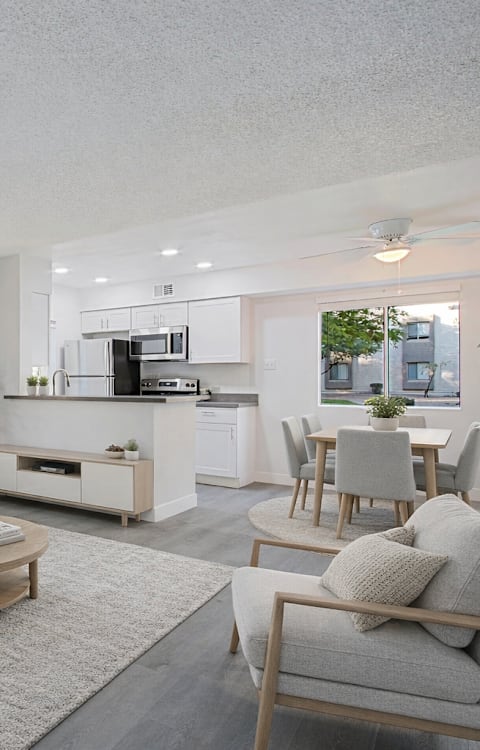 A modern living room with a grey sofa, wooden coffee table, and a grey armchair.