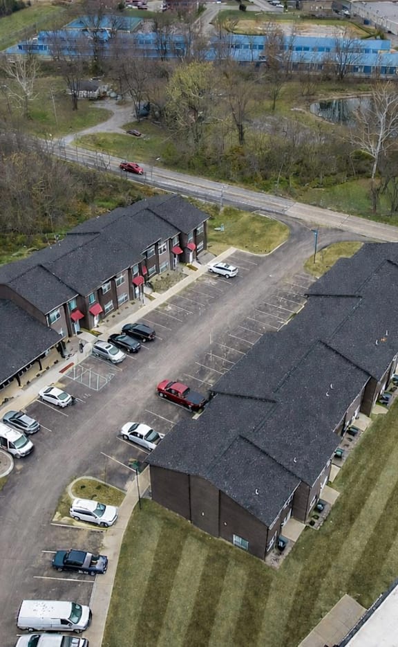 An aerial view of a parking lot with cars and a building.