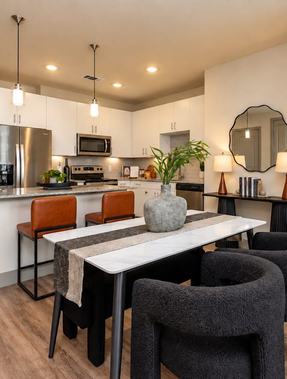 A modern kitchen with a dining table and chairs.