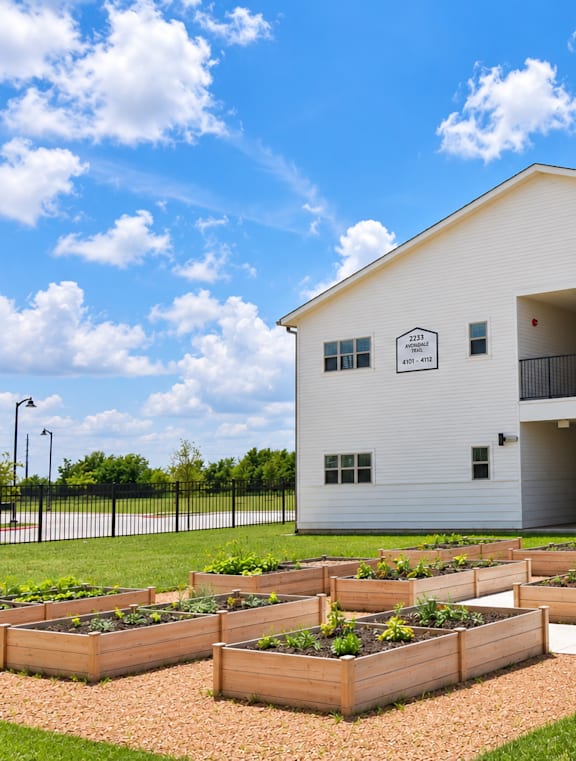 A white building with a garden in front of it.