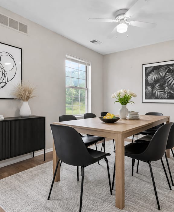 A living room with a grey sofa, a wooden coffee table, and a ceiling fan.