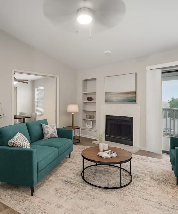 A living room with a green couch, a coffee table, and a fireplace.