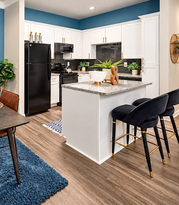 A modern kitchen with a dining table set for two.