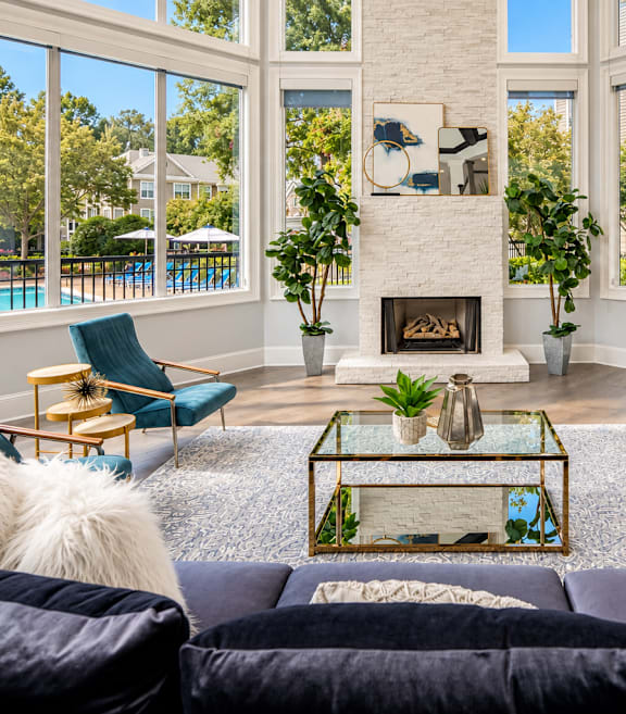A living room with a fireplace and a pool in the background.