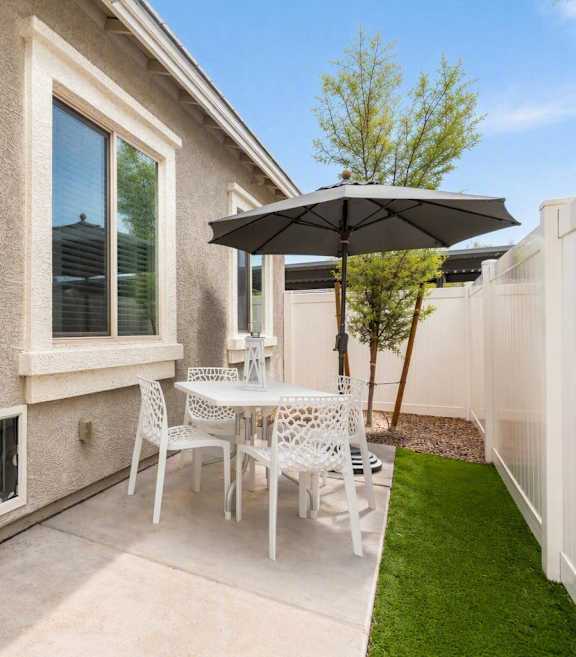 A patio with a white couch, a fireplace, and a television.