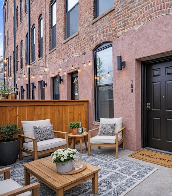 A black door is on the right side of a pink building.