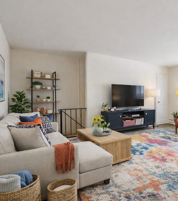 A living room with a couch, a chair, a coffee table, and a television.