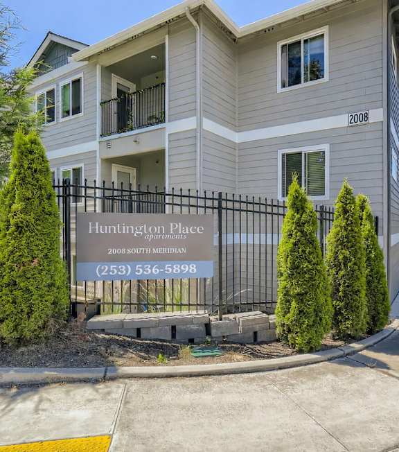 A building with a sign that says Huntington Place in front of it.