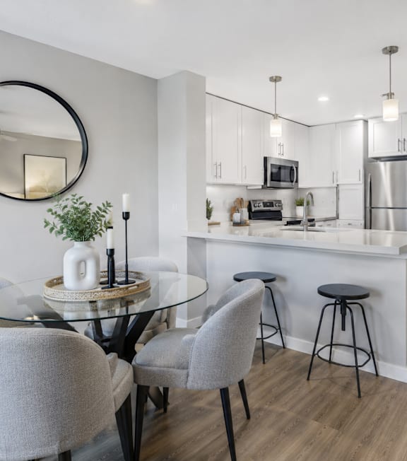 A well-lit, modern kitchen and living room with a dining area.