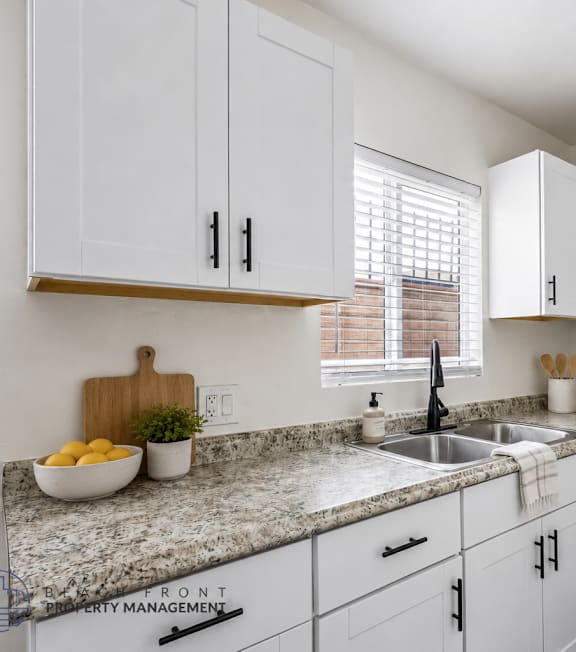 A well-lit, modern kitchen and living room with a dining area.