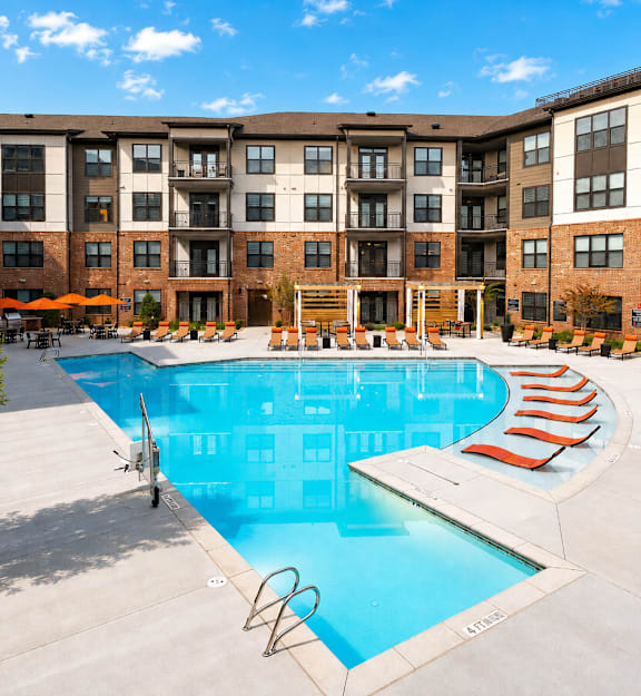 A large swimming pool surrounded by apartment buildings.