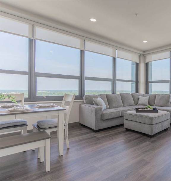 A modern living room with a glass coffee table and a large window.