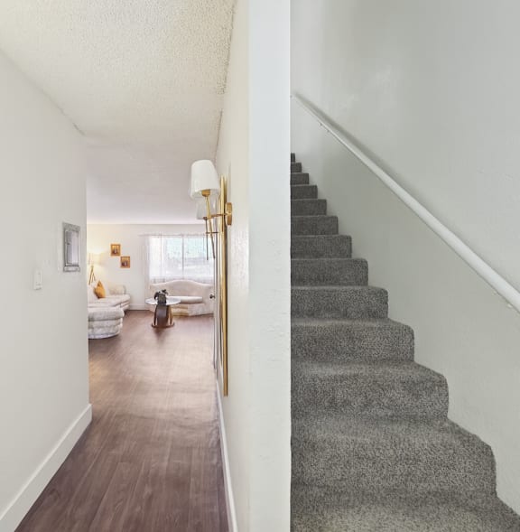 A hallway with a staircase and a lamp.