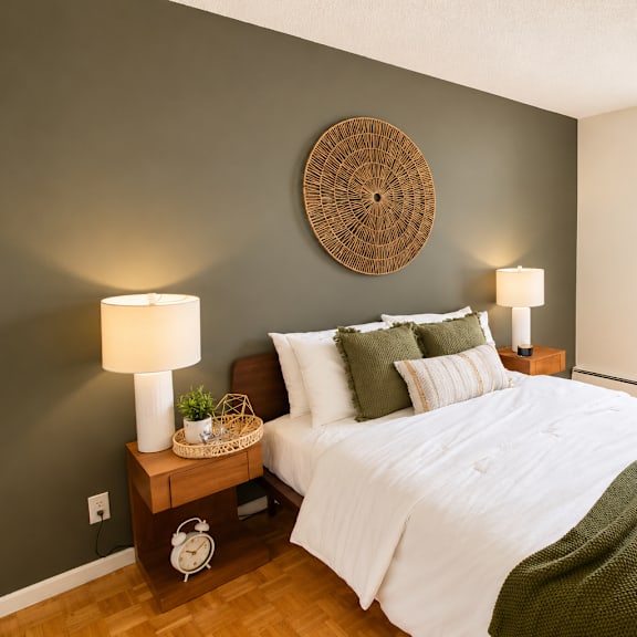 A bedroom with a large bed and a painting on the wall.