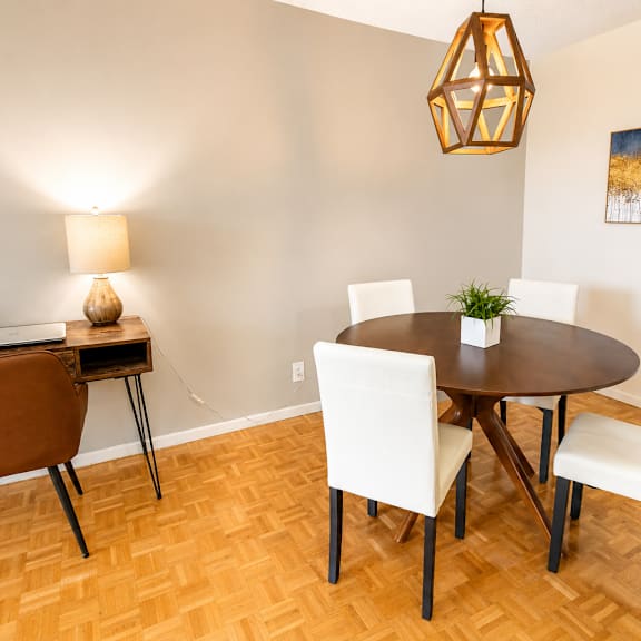 A dining room with a round table and chairs.