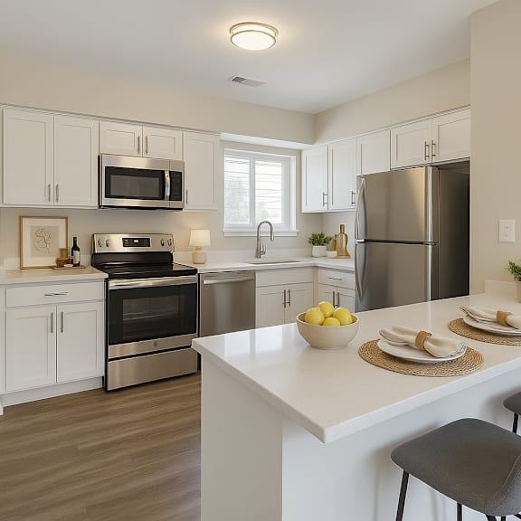 A kitchen with white cabinets and a white island with two chairs.
