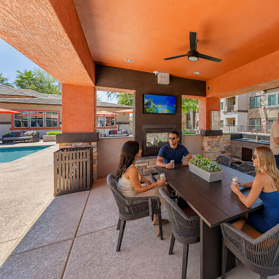A patio with a table and chairs and a grill.