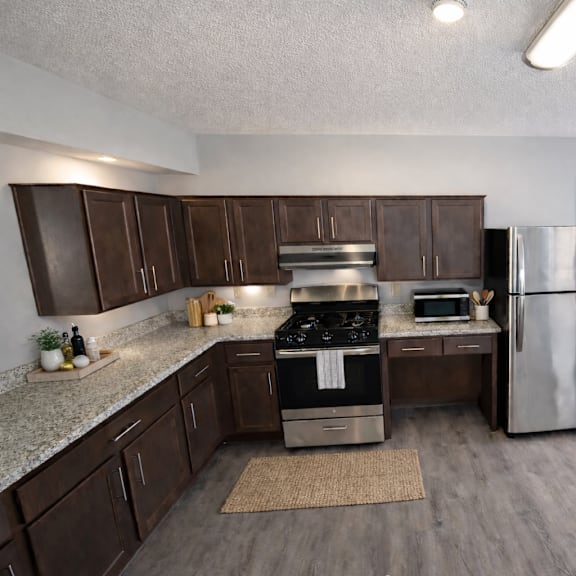 A kitchen with a stove, refrigerator, and cabinets.