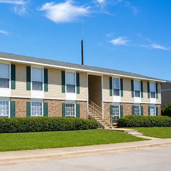 A building with a green lawn in front.