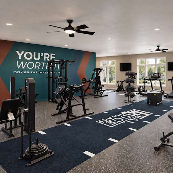 A gym with a variety of equipment and a motivational message on the wall.