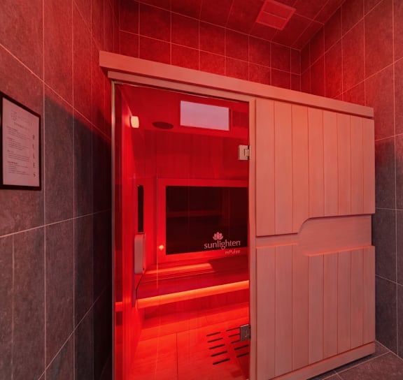 A red lit room with a door in the middle.