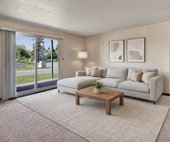 An empty living room with a sliding glass door to a yard at Bay Arms Apartments.
