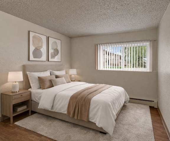 A large, empty carpeted bedroom with overhead lighting, a window, and a closet at the Greenbriar Apartment Homes. 