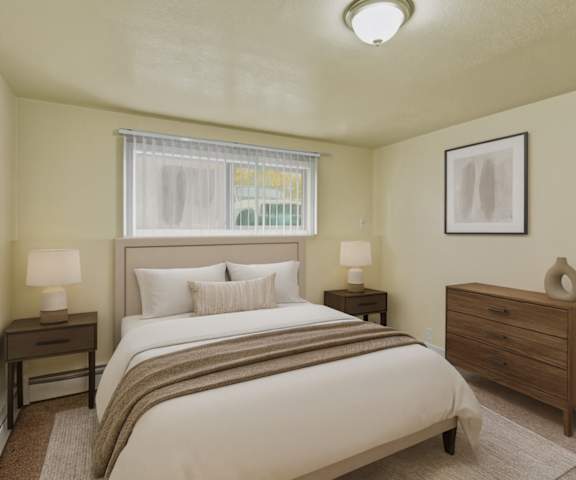 A cozy/large kitchen with white appliances, a light counter with lots of room, and spacious wooden cabinets at Ptarmigan Meadows Apartment Homes. 