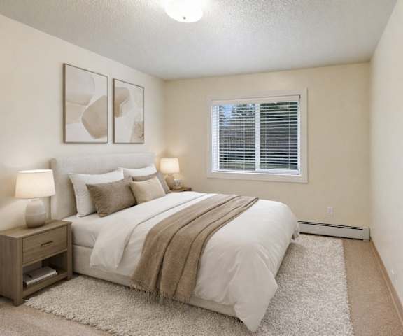 A large empty living room with carpeting and a door to the balcony at Quiet Creek Apartments. 