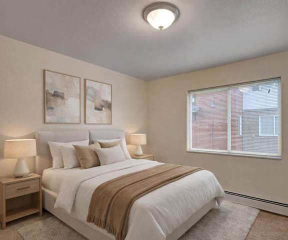 A large, empty carpeted bedroom with overhead lighting and a closet at Strawberry Lane Apartment Homes. 