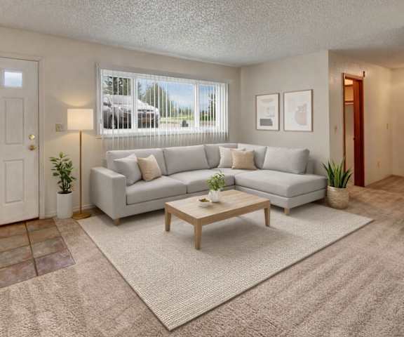 An empty living room with carpeting, a large window showing the stairs, and the front door at Terrace on the Lake Apartment Homes. 