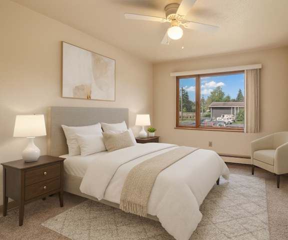 A cozy kitchen with white appliances, kitchen utensils, overhead lighting, light countertops with lots of room, and large wooden cabinets at the Alaskan Apartment Homes. 
