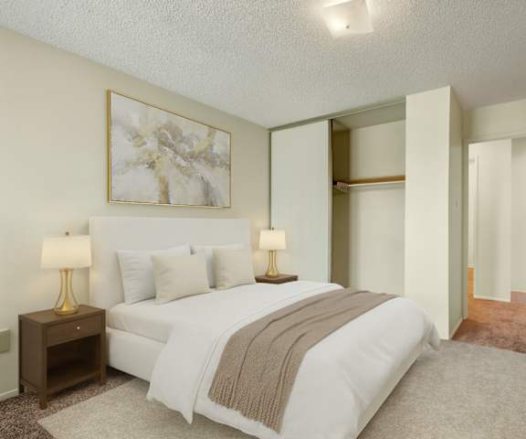 An empty carpeted bedroom with a closet and a door to the hallway at Lakewood Heights.