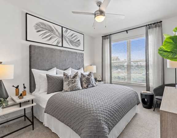A bedroom with a large bed and a grey headboard.