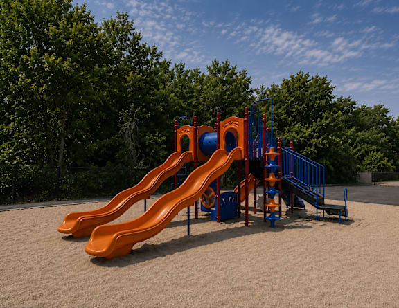 A playground with a yellow slide and a blue climbing frame.