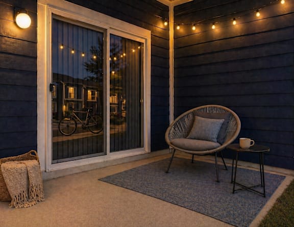 A cozy outdoor space with a chair, table, and string lights.